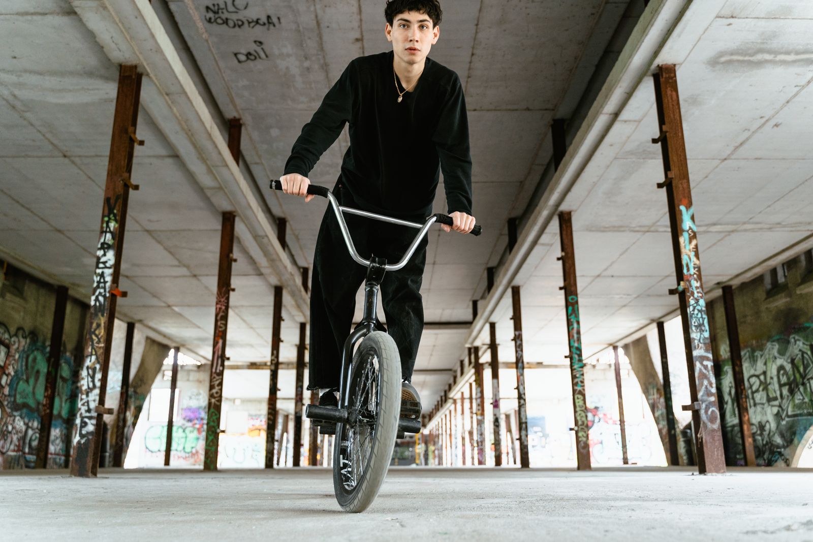 Rider de BMX roulant dans un bâtiment urbain désaffecté