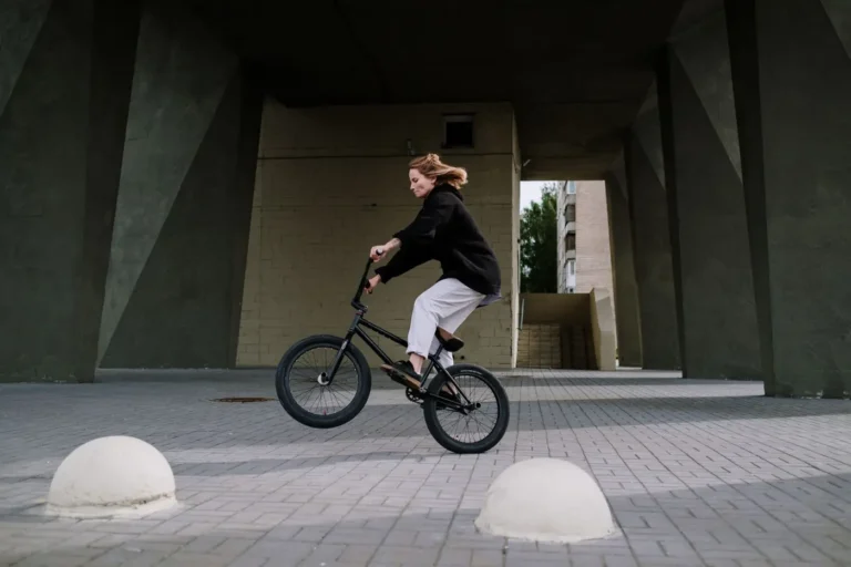 Rideuse réalisant une figure d'équilibre en BMX sur un sol plat
