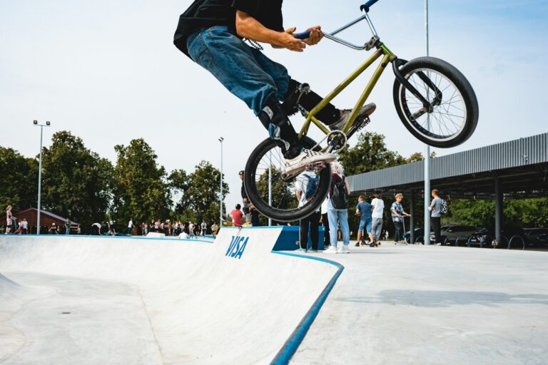 Rider de BMX freestyle décollant d'un module en béton dans un skatepark