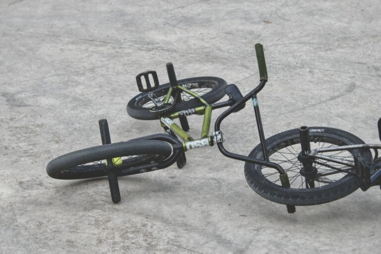 Vélo BMX vert et noir posé au sol sur le béton d'un skatepark