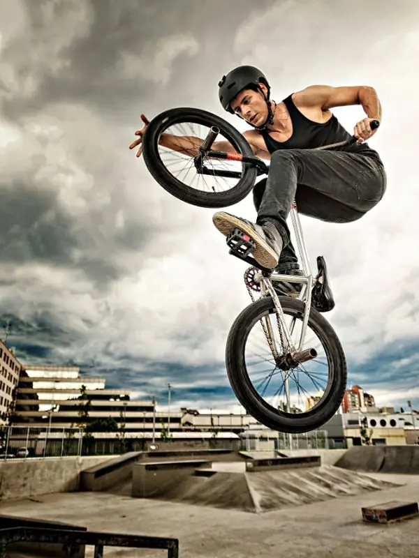 Rider de BMX en saut au-dessus d'un skatepark en béton