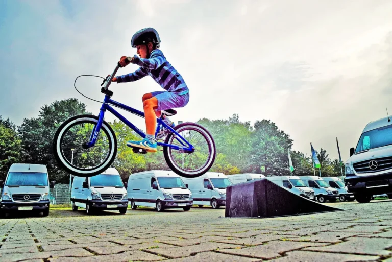 Enfant réalisant un saut en BMX sur un parking