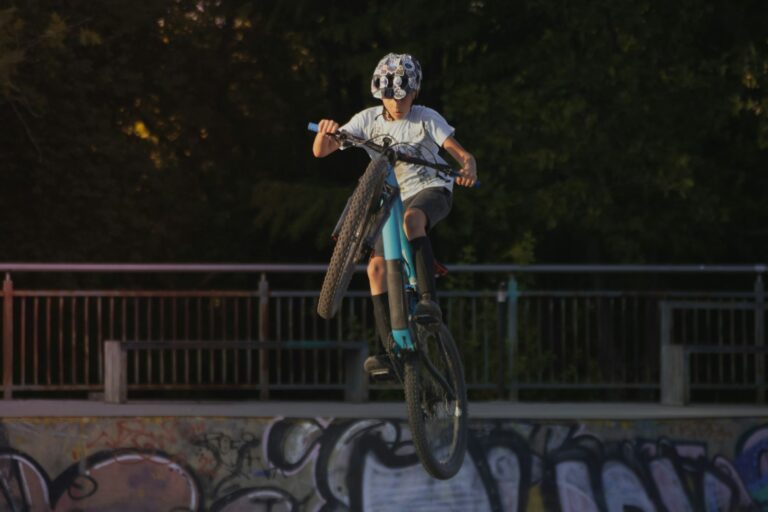 Jeune rider casqué en plein saut sur un BMX