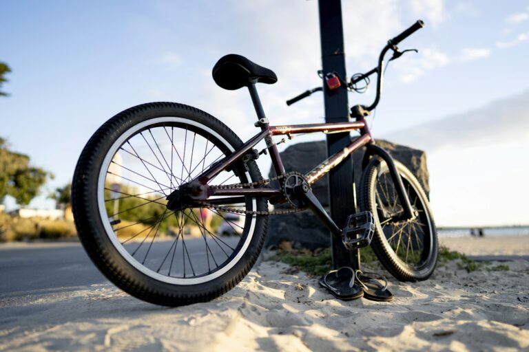 BMX noir appuyé contre un poteau au bord d'une plage