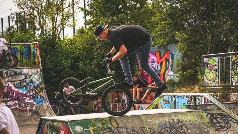 Rider de BMX freestyle en équilibre sur un module de skatepark couvert de graffitis