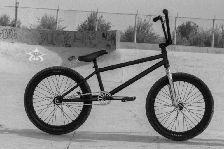 Vélo BMX vu de profil dans un skatepark, photo en noir et blanc