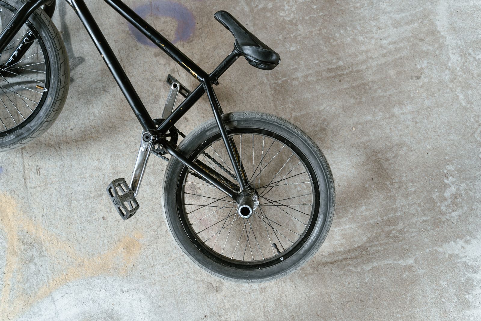 Vélo BMX noir posé sur le béton, vu de dessus